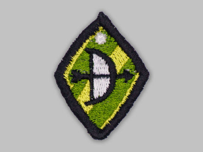 Embroidered patch with a green and yellow diamond shape on a gray background