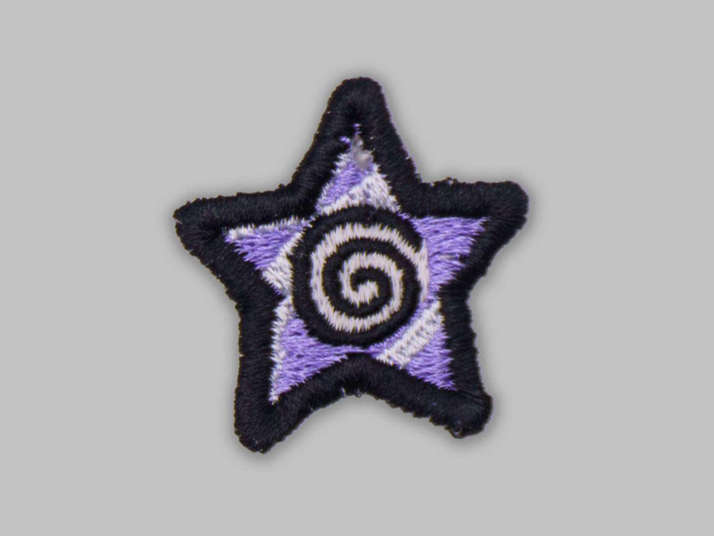 Star-shaped patch with a purple center and black border on a gray background